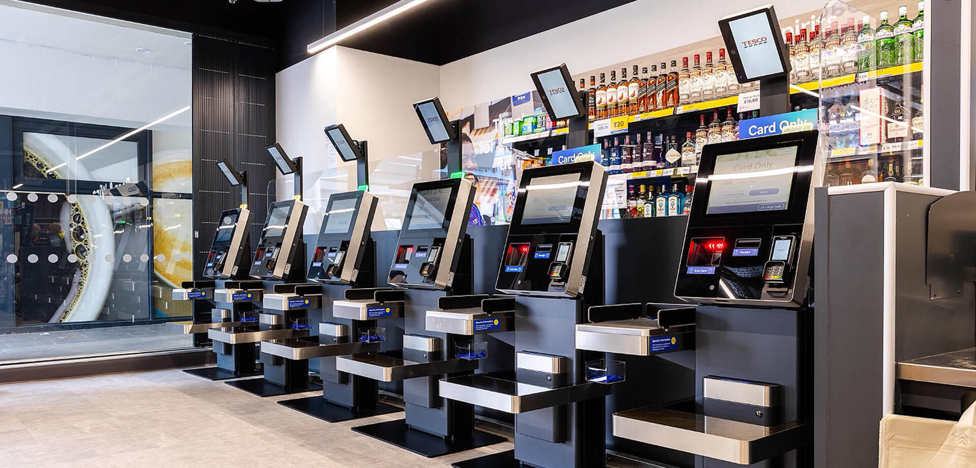 Self-checkout area inside a Tesco Express convenience store.