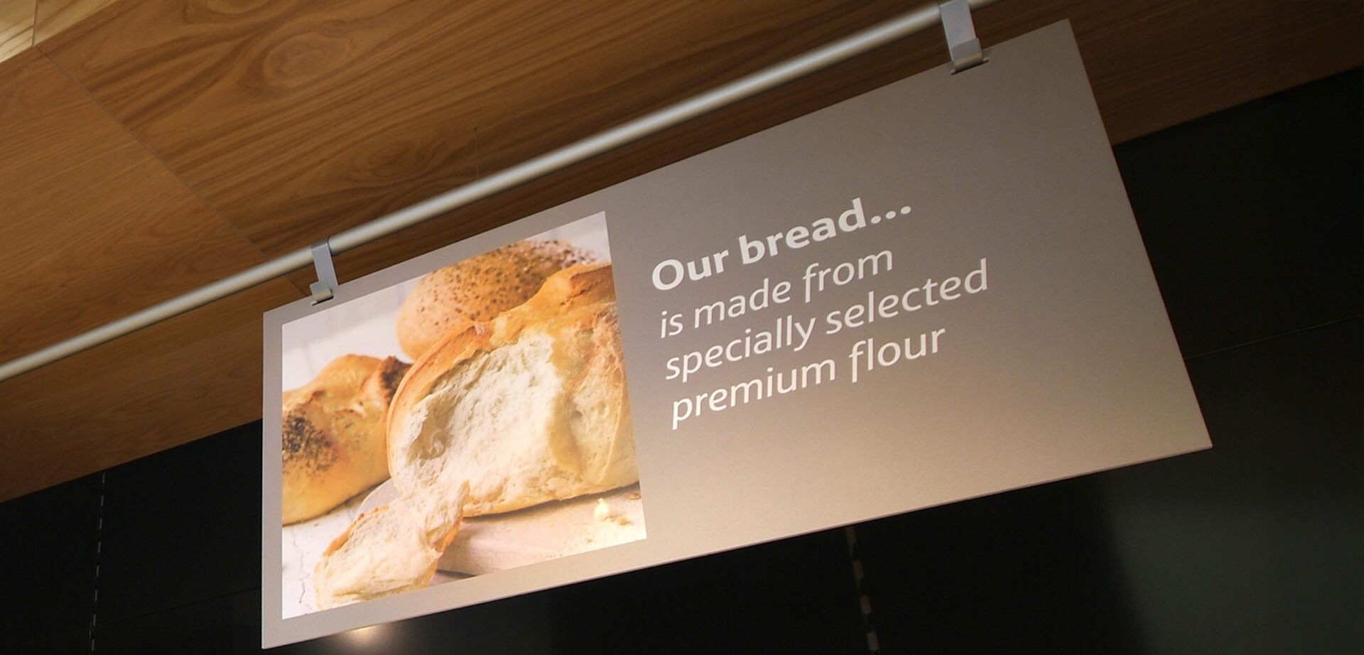 Hipermercado Tesco Extra en Accrington, Lancashire, Inglaterra. La panadería, con su cartelería, suele ofrecer productos como "Favoritos de cada día", "Delicias para la hora del té" y "Los mejores pasteles de autor de Tesco", ofreciendo tanto productos estándar como especiales, como panes de molde, focaccia y masa madre.