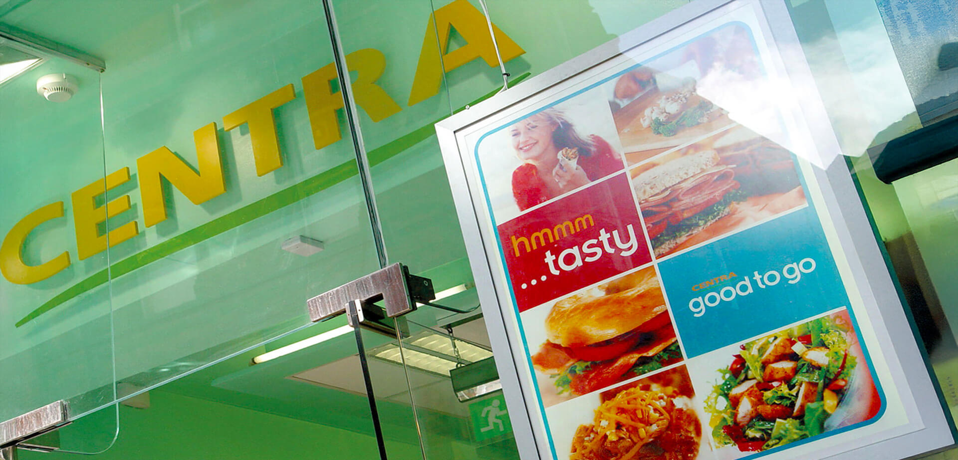 The image displays the storefront and advertising for Centra, an Irish convenience retailer known for its food-to-go options. Centra is an award-winning convenience retail group with over 486 stores, primarily located across Ireland.
