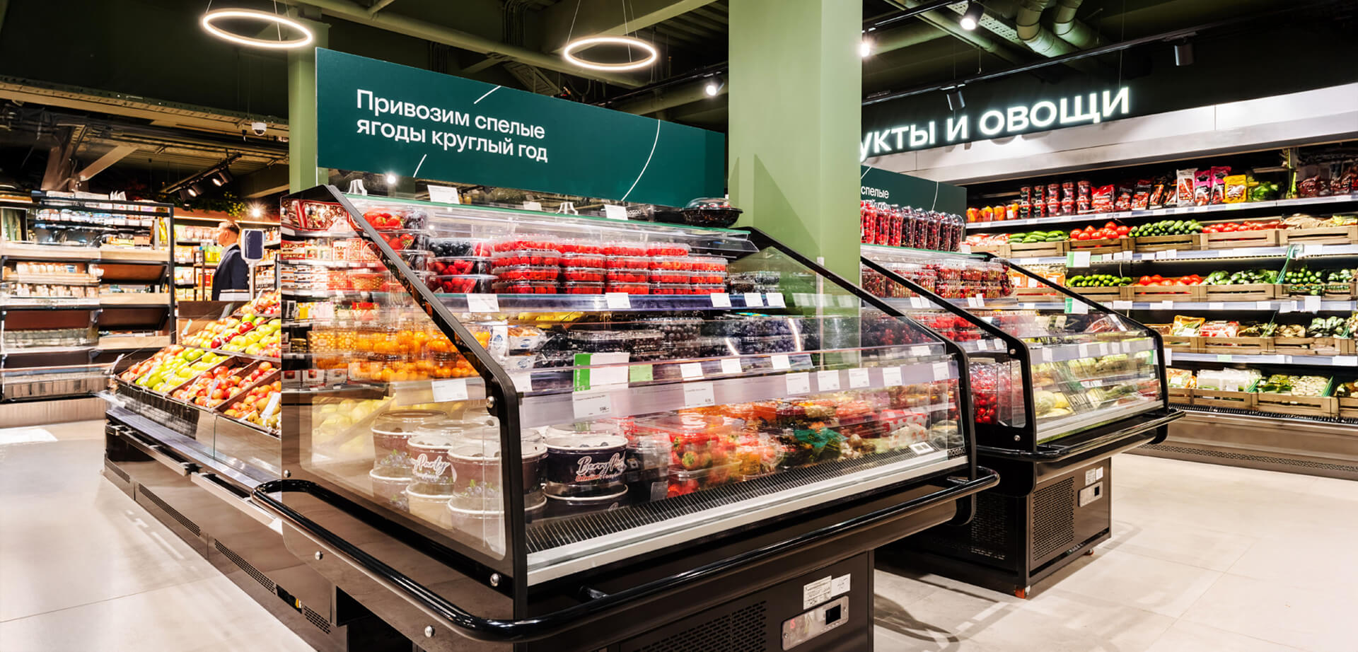 Der Supermarkt „Azbuka Vkusa“ ist eine russische Einzelhandelskette, die für ihre hochwertigen Lebensmittel bekannt ist. Die Schilder weisen darauf hin, dass der Laden ganzjährig reife Beeren und anderes Obst und Gemüse anbietet.