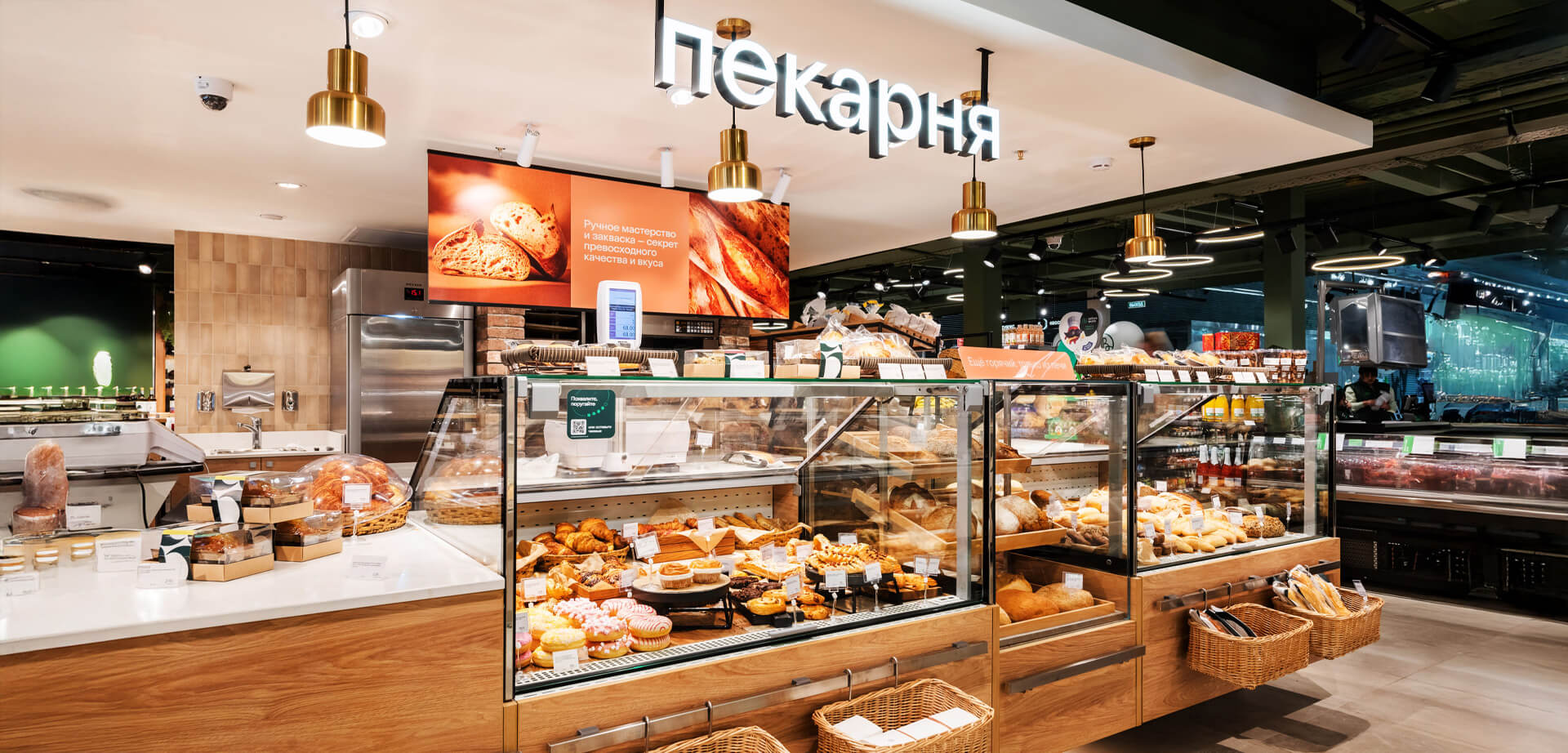 Über dem Regal des Supermarkts Azbuka Vkusa steht das Schild „пекарня“, was auf Russisch „Bäckerei“ bedeutet.
