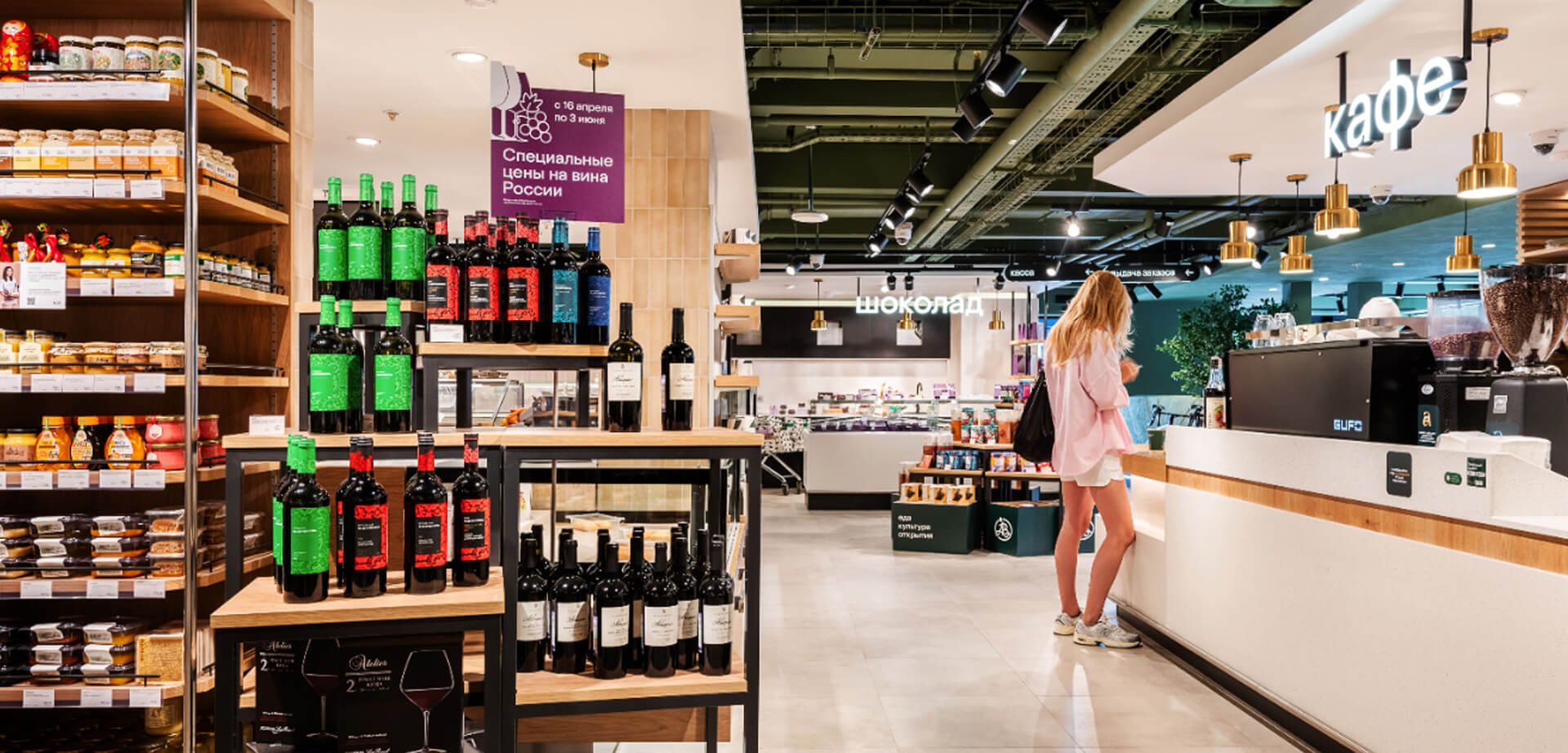 Im Azbuka Vkusa Supermarkt ist der Cafébereich an dem großen „Kafé“-Schild über der Theke erkennbar. Außerdem gibt es Schilder mit der Aufschrift „Schokolade“, die auf eine Schokoladen- oder Dessertabteilung hinweisen.