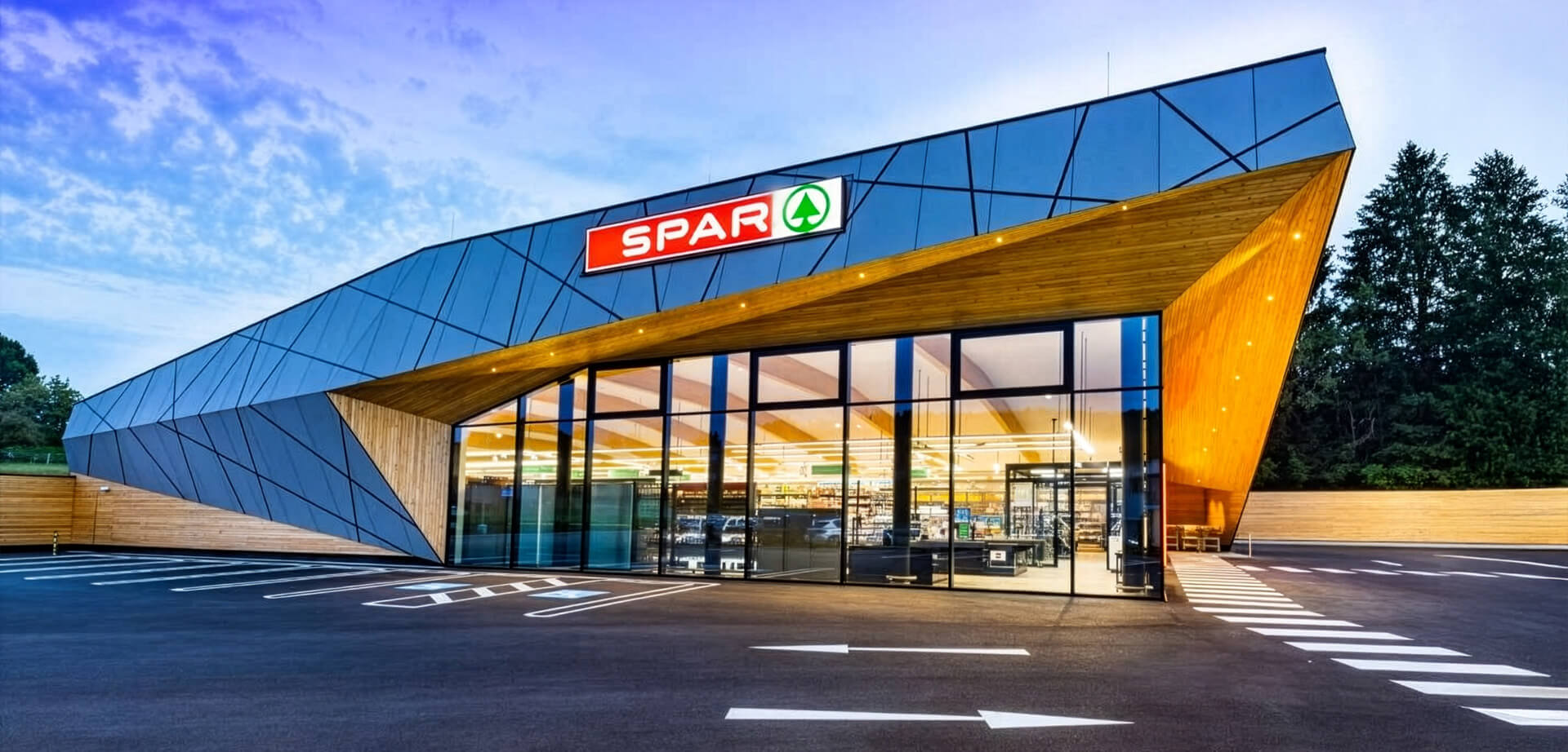 The image shows a modern-designed SPAR supermarket located in Weinitzen, Austria.