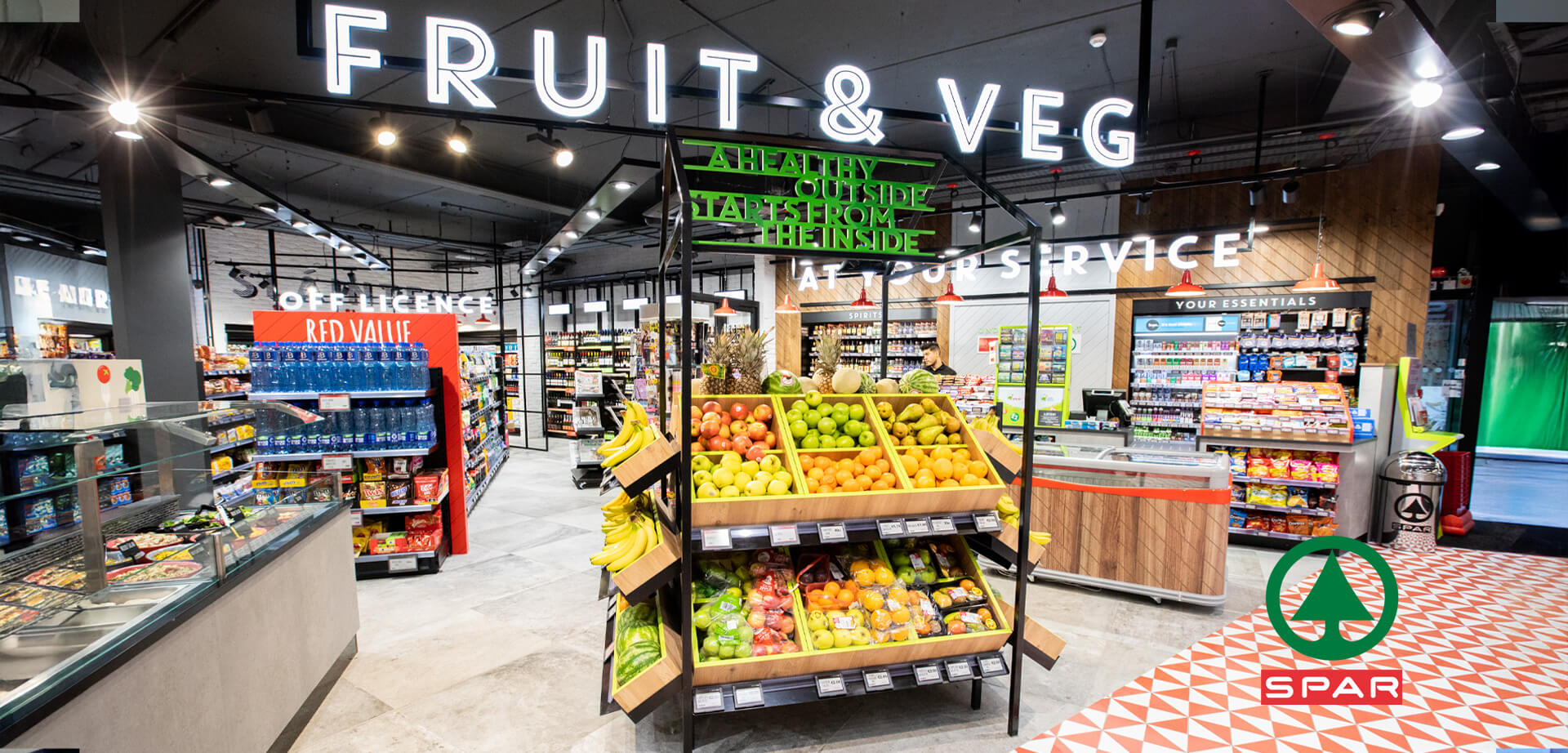 The interior of a modern SPAR convenience store, likely a "fresh store" format. This design concept emphasizes fresh food and an appealing market-style layout.