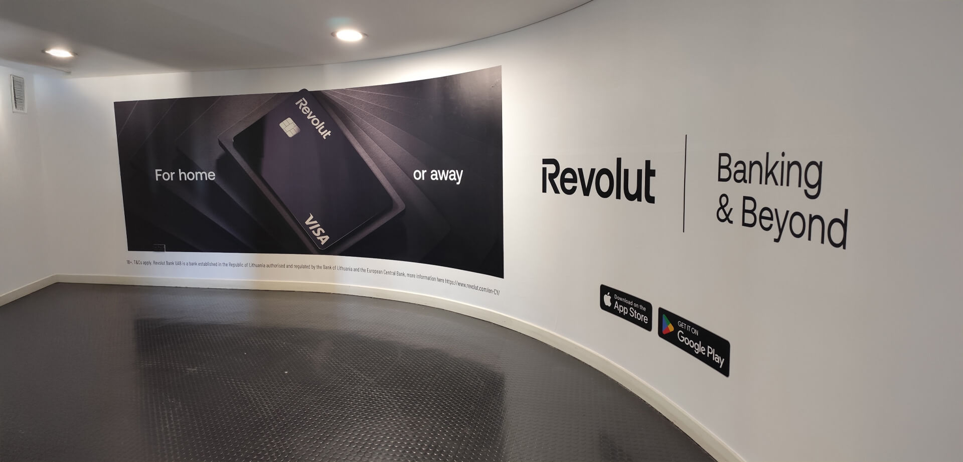 This image shows a marketing display for Revolut banking services in an airport walkway, highlighting their financial products for domestic and international use.