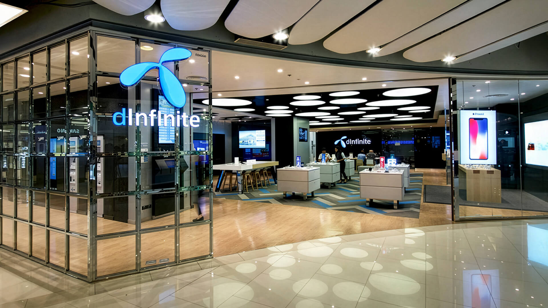 The image shows a dInfinite flagship service center by the Thai mobile provider DTAC, located within a major shopping mall.Store Concept: This modern, experiential retail prototype was designed by the agency Whitespace.