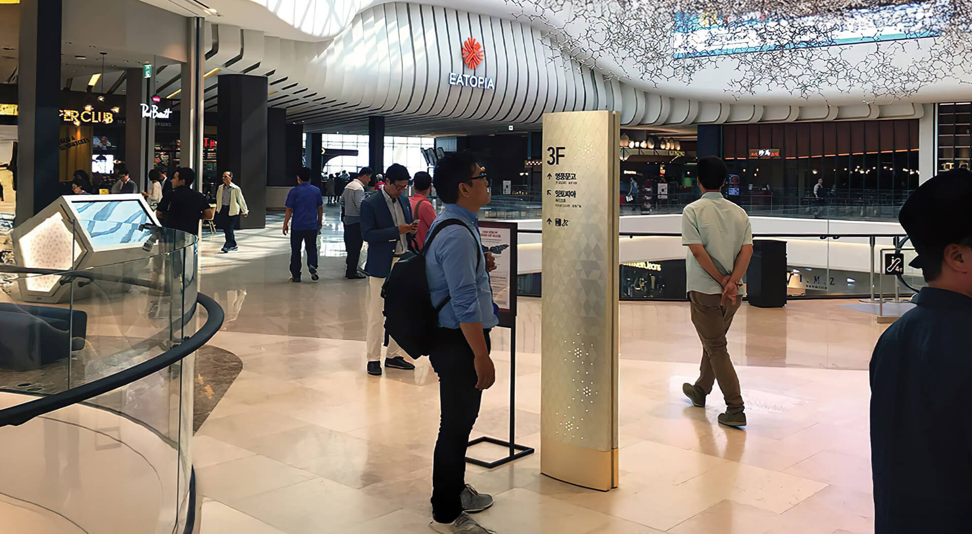 An interior view of Starfield Hanam, retail signage, and visitors exploring the shopping centre.