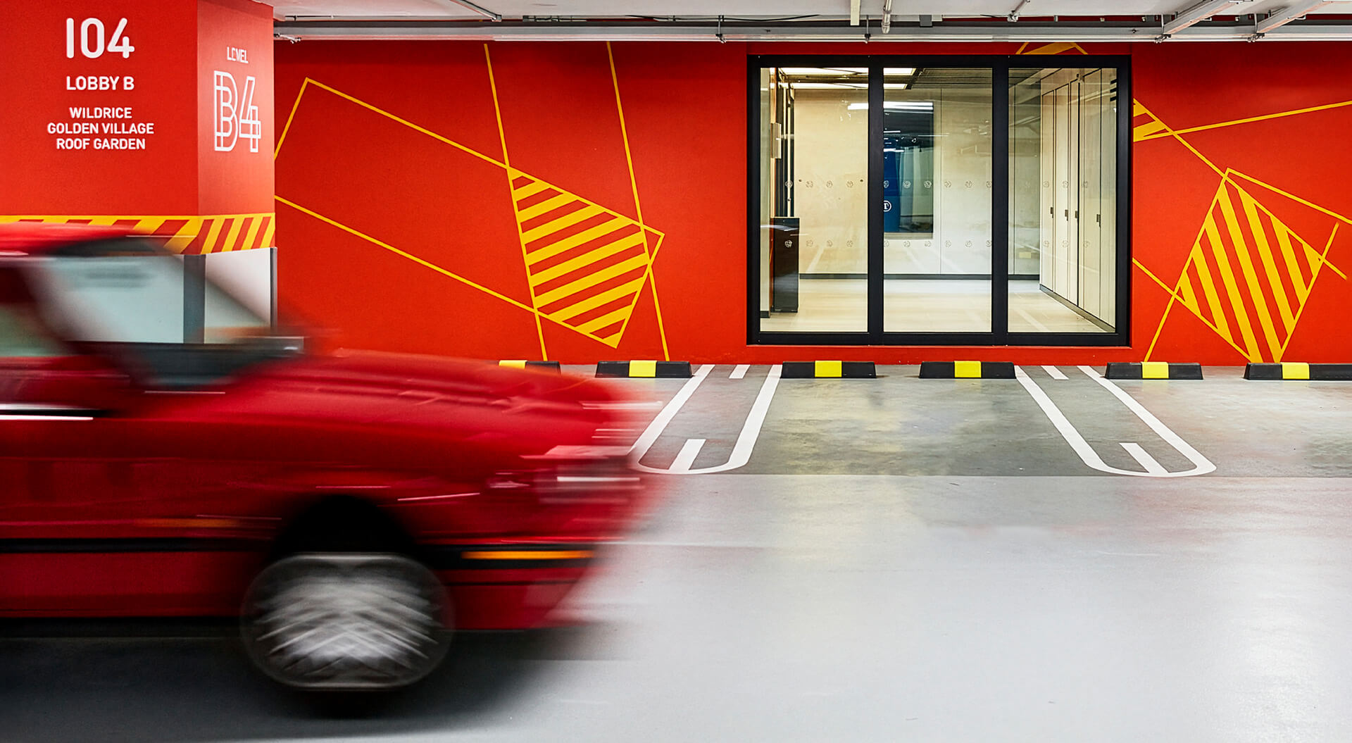 Funan Mall in Singapore, featuring vibrant red walls, yellow geometric wayfinding graphics, and a motion-blurred red car.